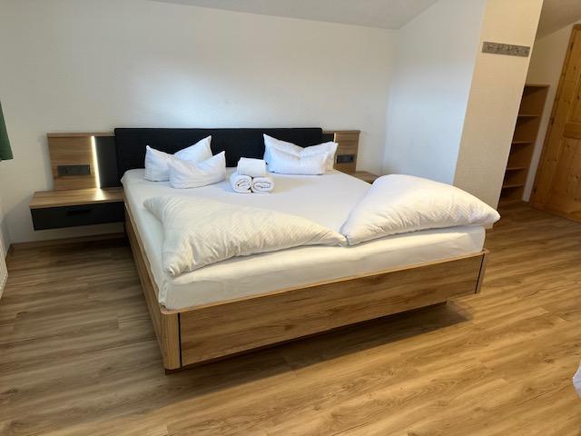 Frisch bezogenes Hotelbett mit wei&szlig;er Bettw&auml;sche